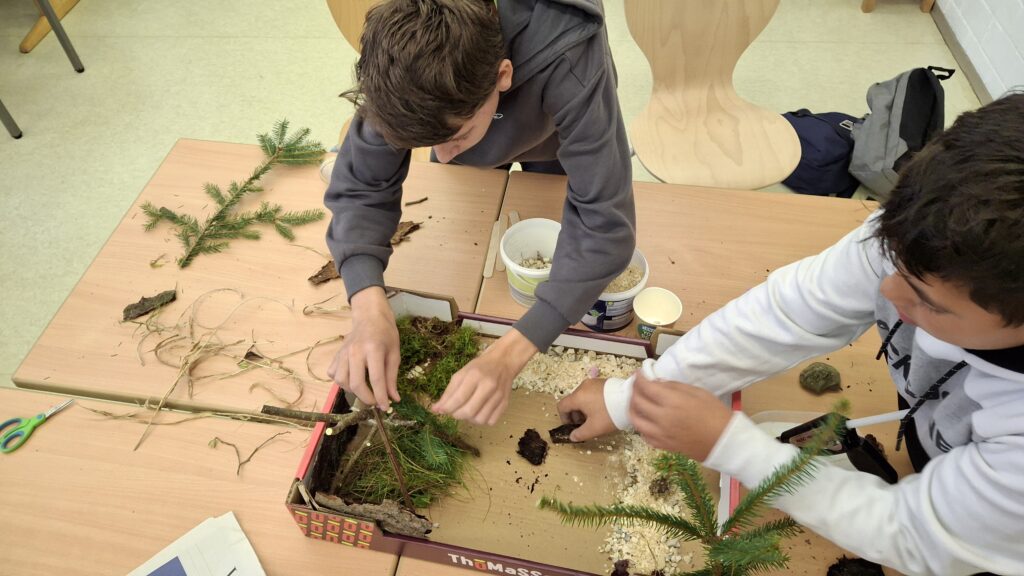 zwei Schüler bauen ein Modell von ihrem Schulgelände