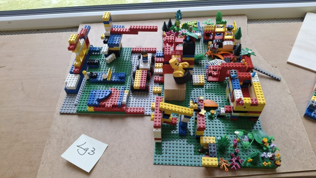 Grundschüler:innen haben ein Modell ihres Schulgeländes aus Lego Steinen gebaut