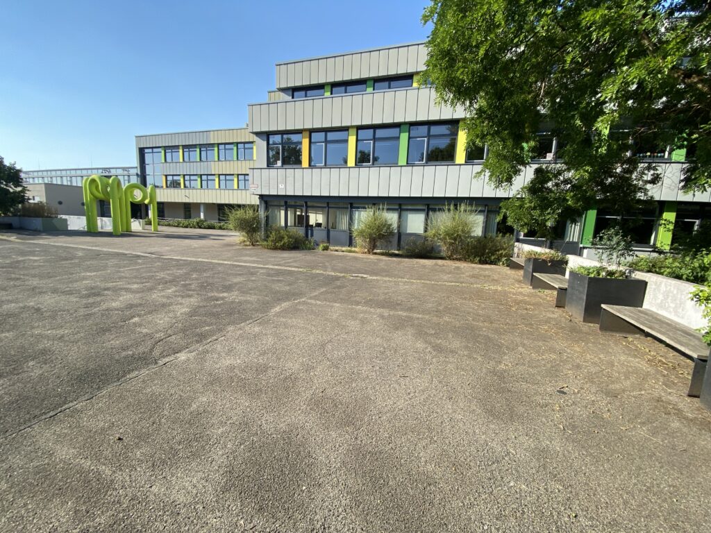 asphaltierter Schulhof und Schulgebäude
