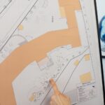 Ein Finger zeigt auf die Skizze der naturnahen Gestaltung des Hinterhofs am Wagenburg Gymnasium.