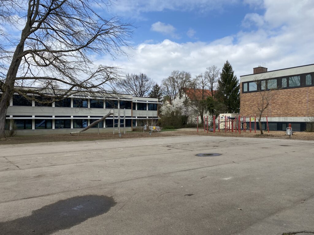 geteerter Pausenhof mit Rutsche und Klettergerüst