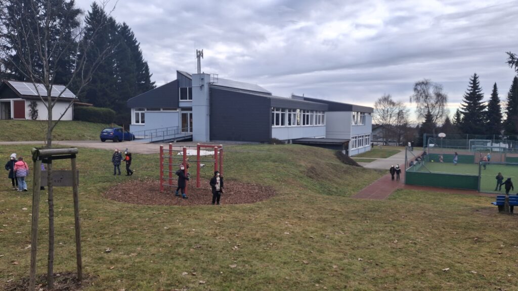 Wiese am Hang, Klettergerüst, Fußballplatz und Schülerinnen
