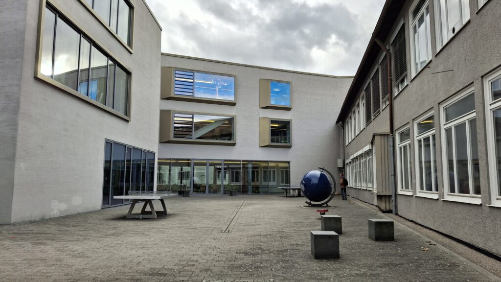 gepflasteter Innenhof mit Tischtennisplatte und Globus